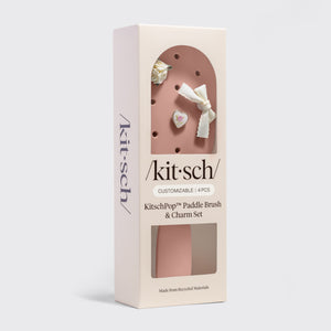 Kitsch paddle brush and charm set packaging on a light gray background