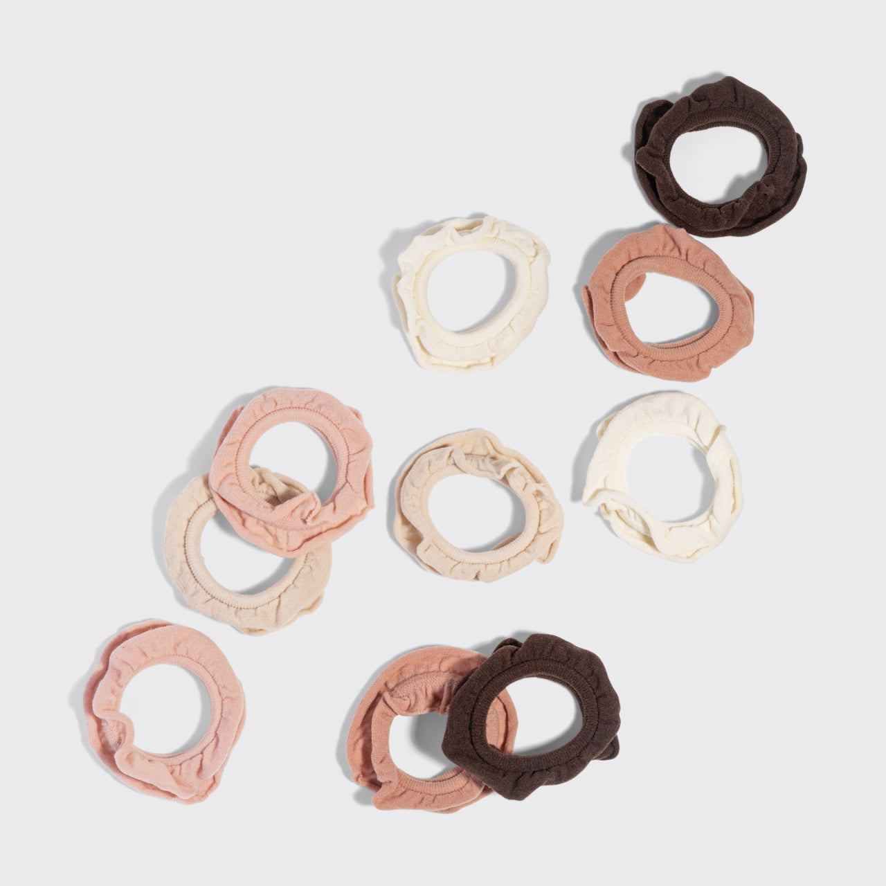 Set of Kitsch Blush Petal Hair Elastics in cream, beige, blush, and brown on a light gray background