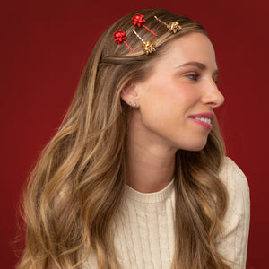 KITSCH Red & Gold Metal Gift Bow Bobby Pins 4pc Set — model with the gold and red bow pins lined up along a half-up section of her hair — Adds an effortless, festive accent to everyday hairstyles — holiday parties and everyday looks