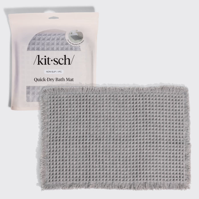 Kitsch Quick-Dry Bath Mat in gray hero image, shown with its retail packaging (non-slip, 1 piece) behind the folded mat.