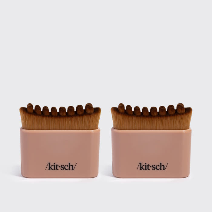 Two terracotta KITSCH Lymphatic Contour Face Brushes, front-facing packaging shot