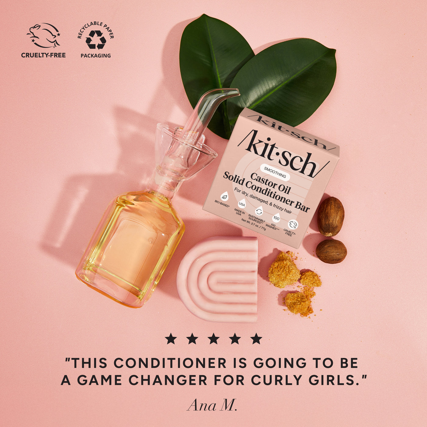 kitsch castor oil solid conditioner bar with a bottle of castor oil on a pink background. There is a Leaping Bunny badge and a Recycle paper packaging badge in the upper left corner. On the bottom of the image is a 5 star customer review that says "this conditioner is going to be a game changer for curly girls"